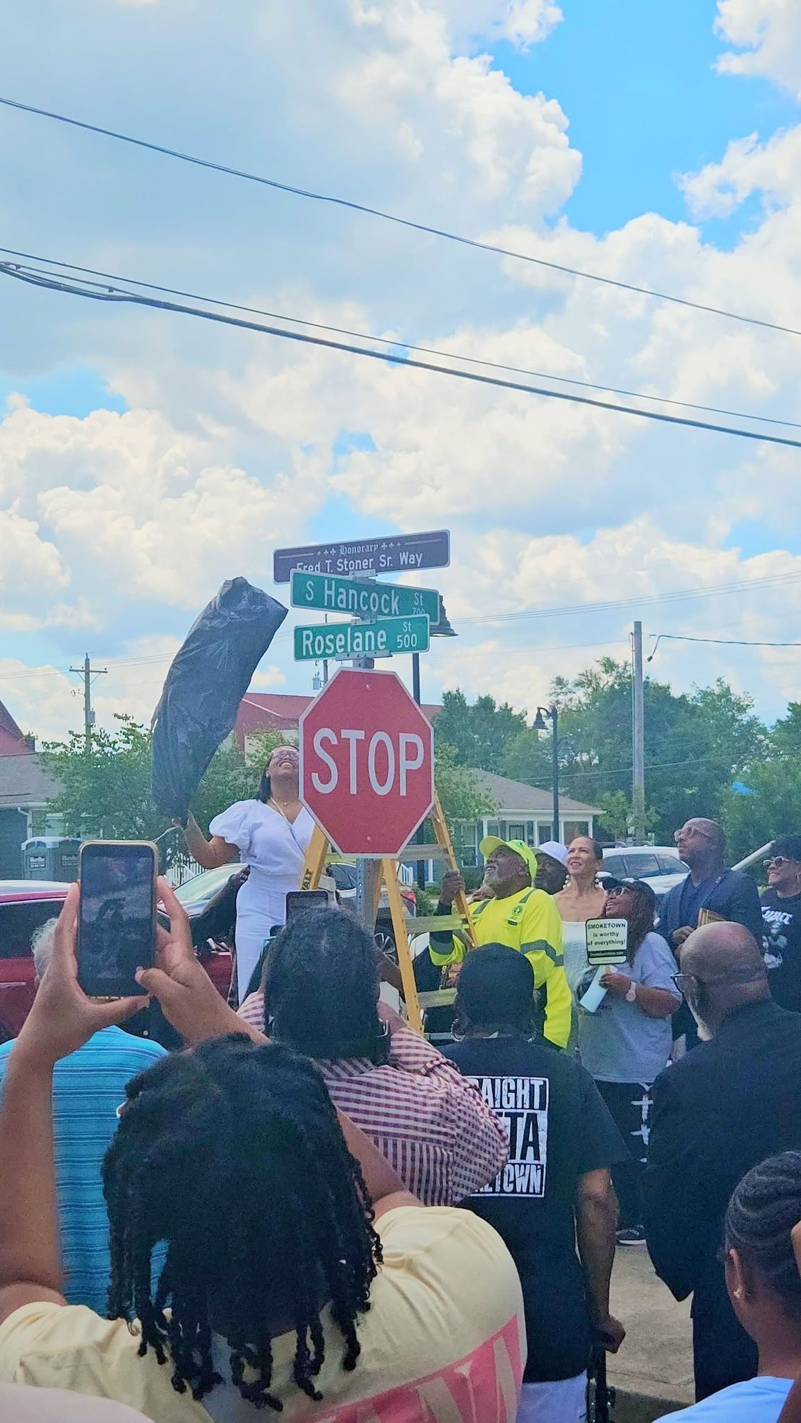 Crowd celebrating beneath the newly installed street signs