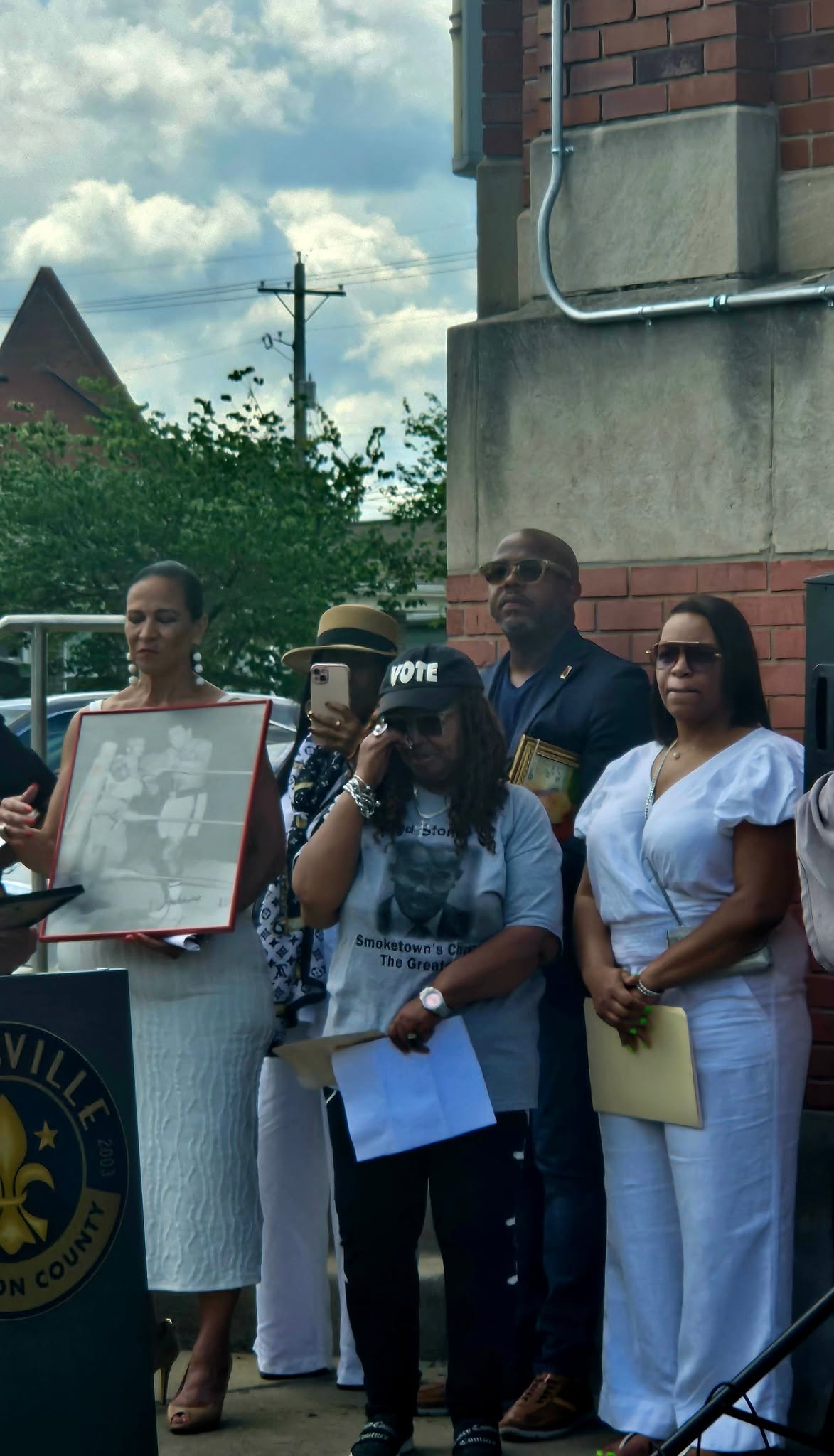 Family holding framed photos of Fred T. Stoner Sr.